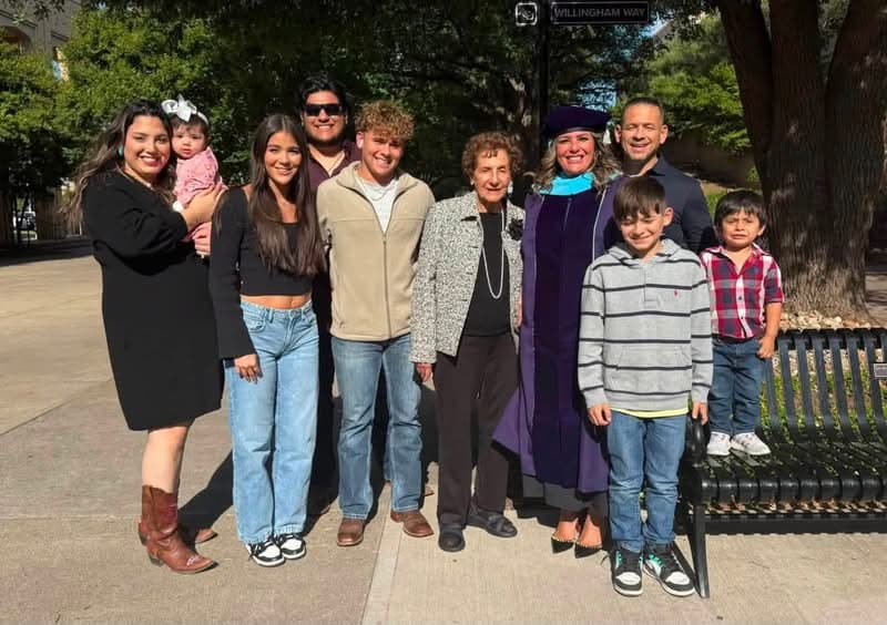 Dr. Karla in regalia surrounded by three generations of her family after her doctoral graduation